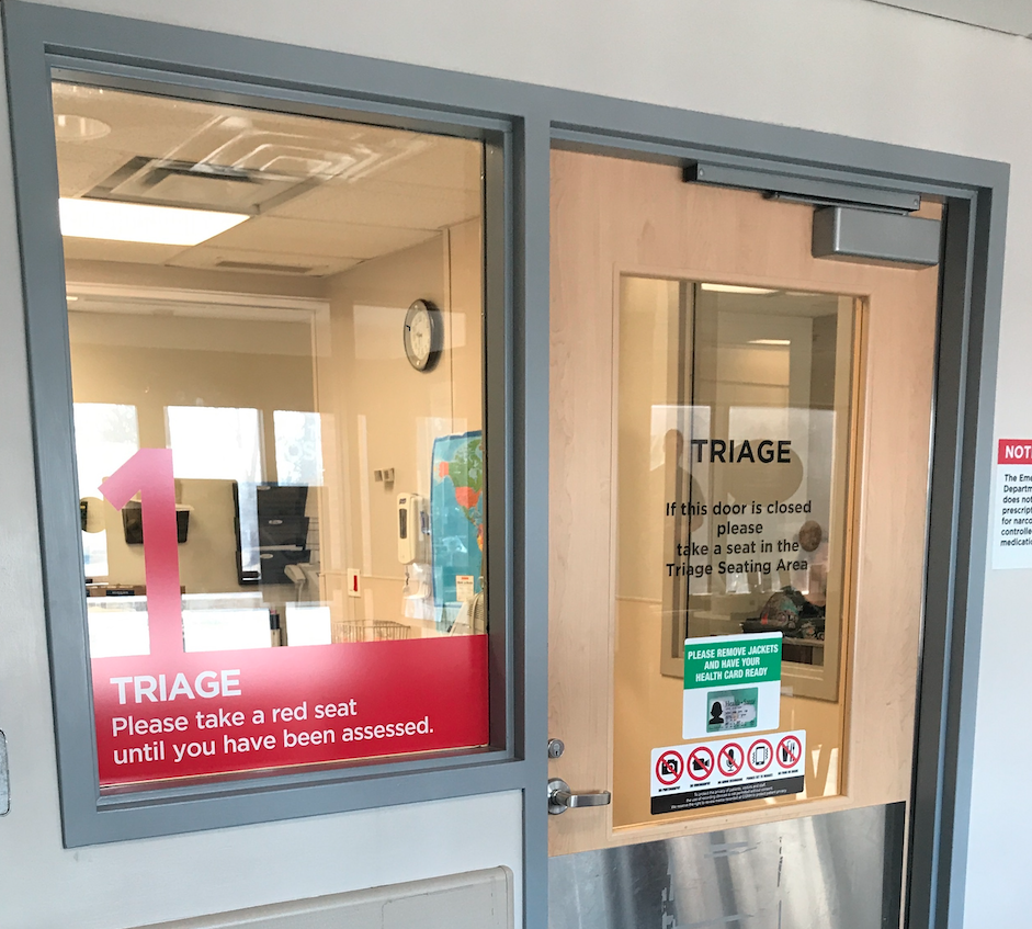 Glass window and door with red writing in Emergency Department